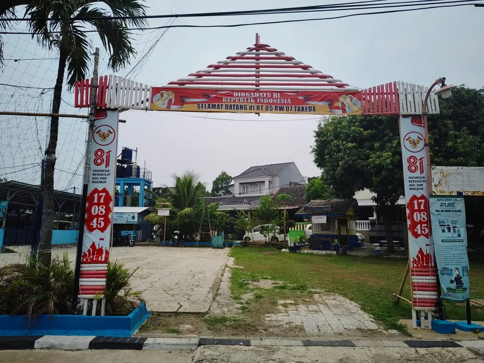 Gapura masuk bertuliskan Selamat datang di RT 05 RW 07 Takeda, dihias merah putih untuk HUT RI ke-81.